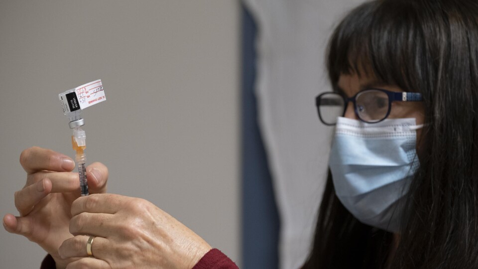 Une infirmière clinicienne prépare un vaccin contre la COVID-19.