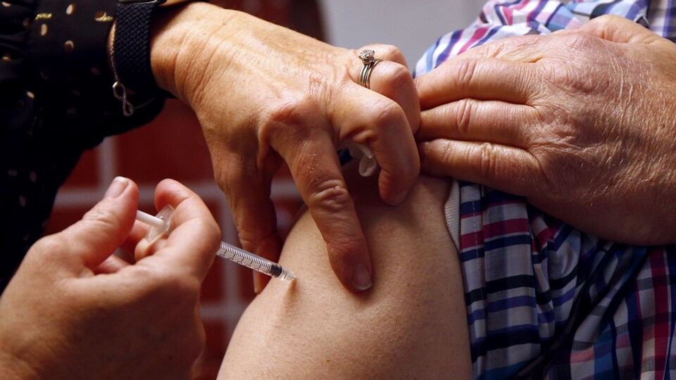 Une infirmière administre une dose de vaccin contre la COVID-19.