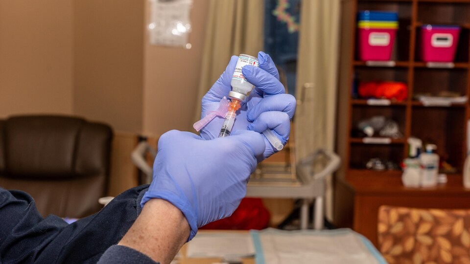 Une seringue dans un flacon du vaccin de Moderna. 