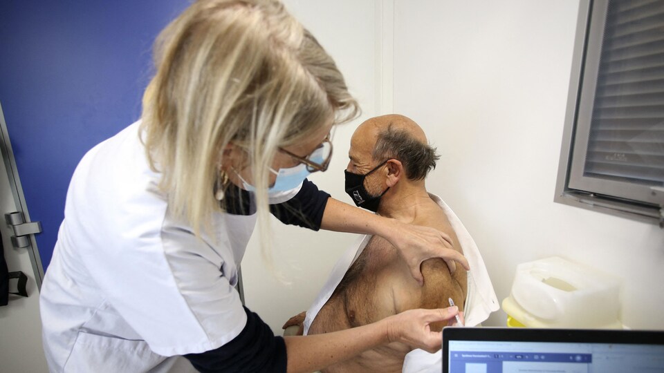 Une infirmière administre un vaccin à un homme âgé.