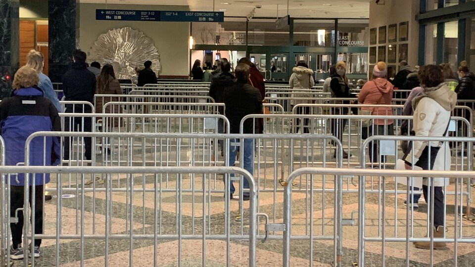 Des grilles et des gens qui attendent.