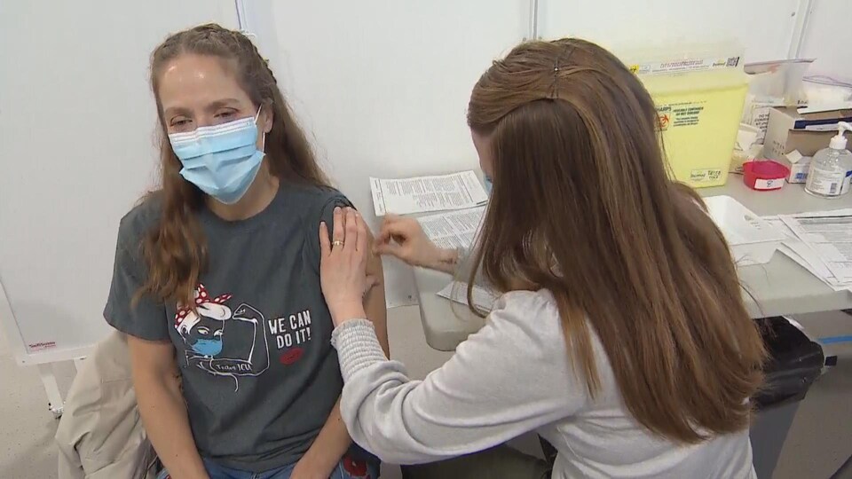 Une infirmière prépare une patiente à recevoir le vaccin contre la COVID-19, à Saskatoon.