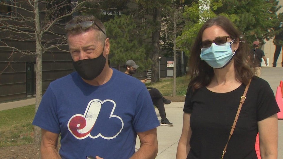 Deux personnes portent un masque