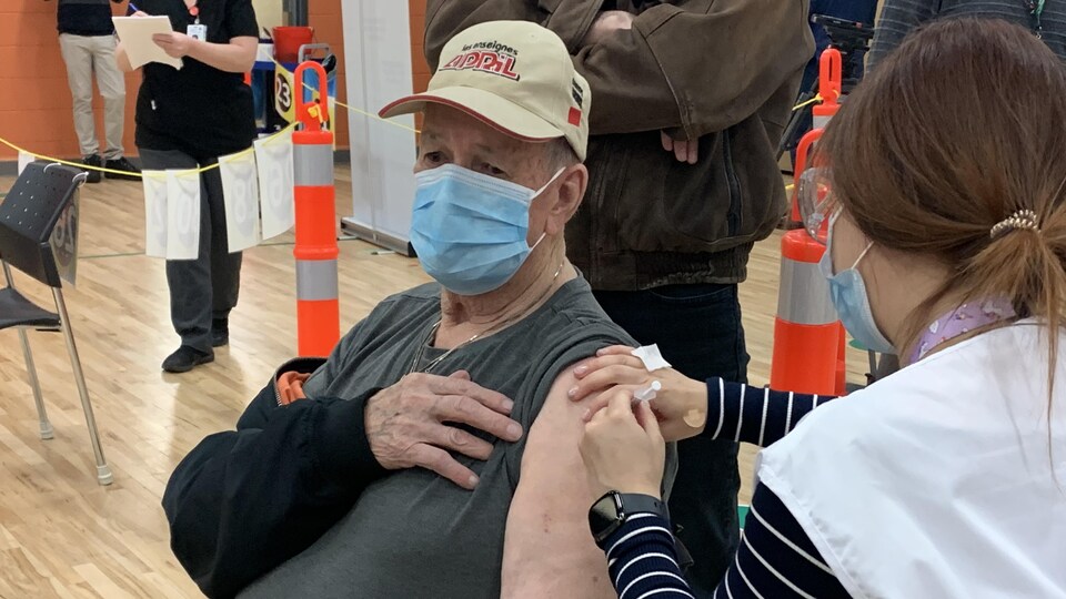 Un homme reçoit sa première dose de vaccin.