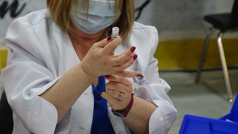 Une infirmière prépare une dose de vaccin contre la COVID-19 le 11 mars 2021 à Matane.
