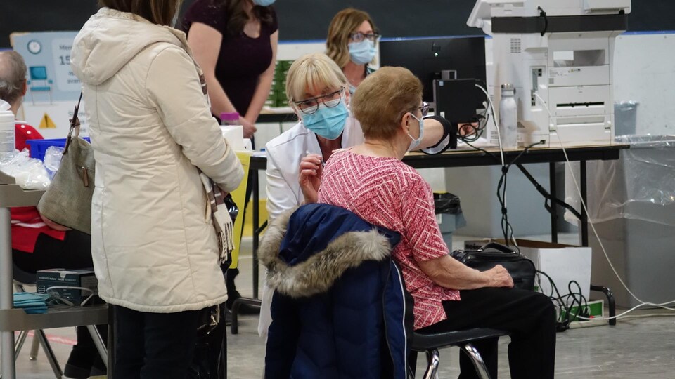 Une femme reçoit une dose de vaccin contre la COVID-19, le 11 mars 2021 à Matane.