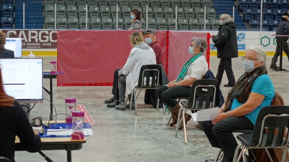 Des personnes attendent de recevoir une première dose du vaccin contre la COVID-19, le 11 mars 2021 à Matane.