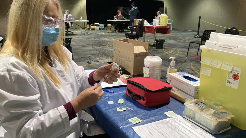 Une femme se prépare à administrer un vaccin.