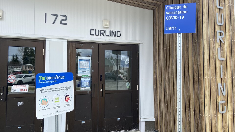 Les mesures sanitaires comme le lavage des mains, se tenir à 2 mètres de distance des autres et tousser dans le coude sont affichés devant l'entrée d'une clinique de vaccination à Amos.