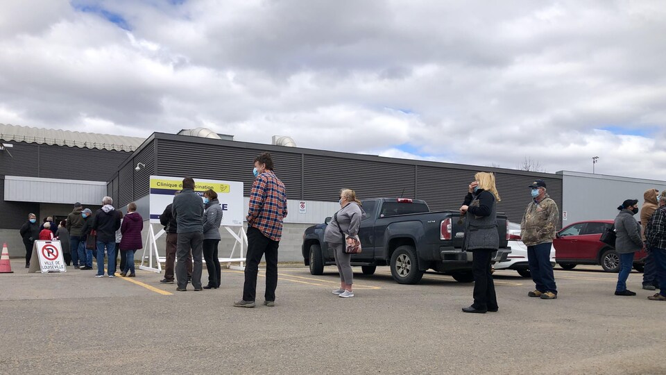 Des personnes font la file devant le centre de vaccination de Louiseville
