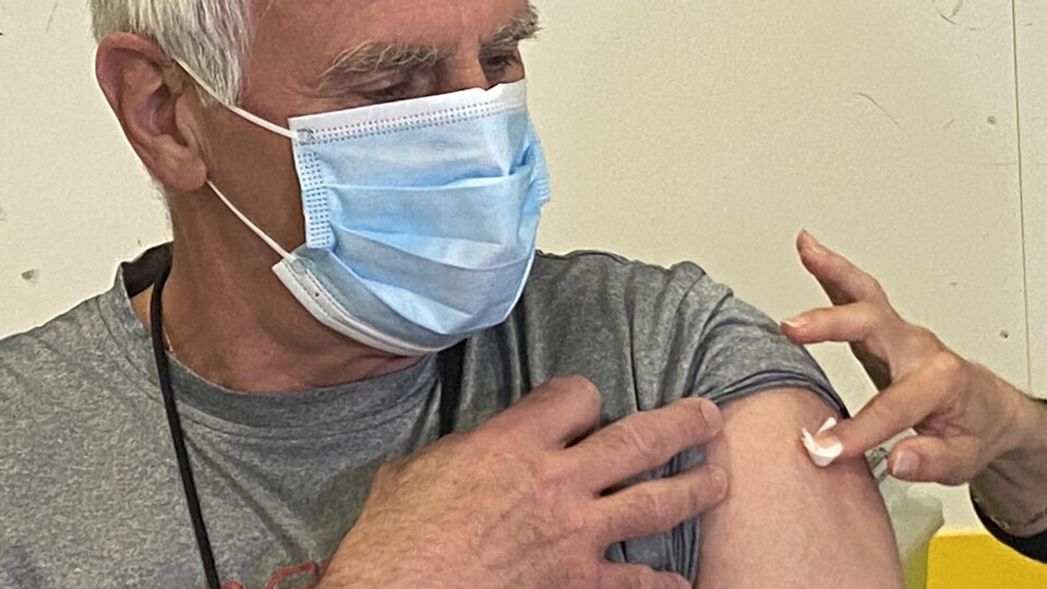 Une personne se prépare à recevoir le vaccin d'AstraZeneca