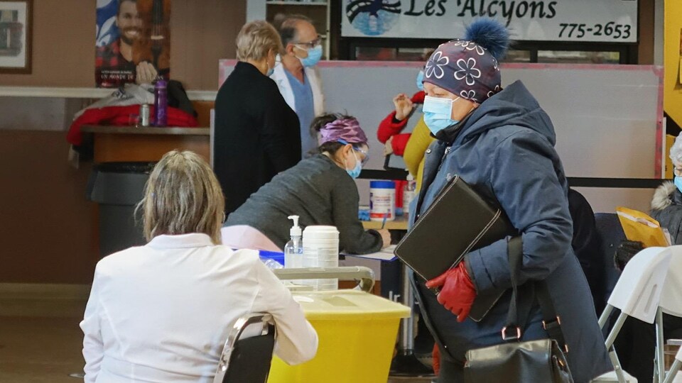 Des personnes avec des masques dans une salle.
