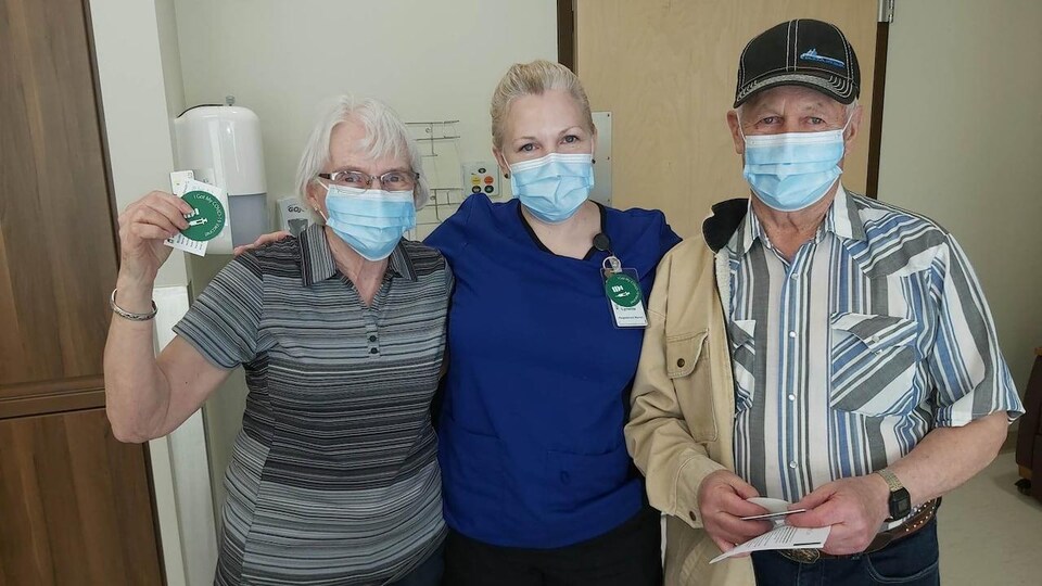 Une infirmière en compagnie de ses parents dans un centre de vaccination.