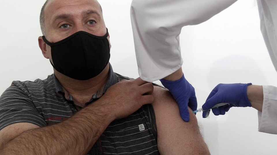 Un homme se fait vacciner.