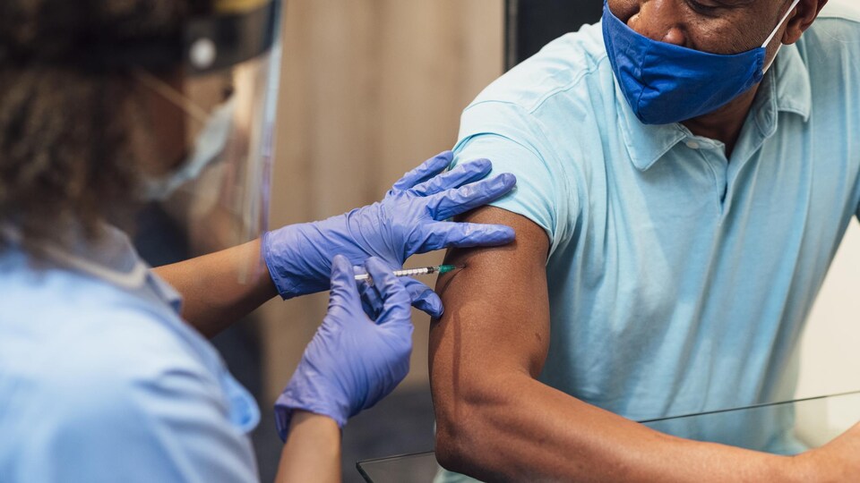 Un homme reçoit une dose de vaccin contre la COVID-19.