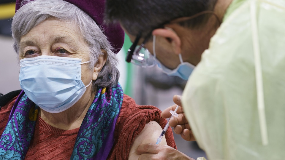 La femme se fait vacciner sur le bras.