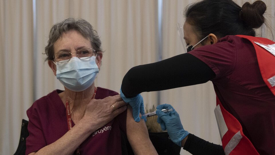 Une dame reçoit le vaccin COVID-19 de Pfizer-BioNTech à l'hôpital d'Ottawa.