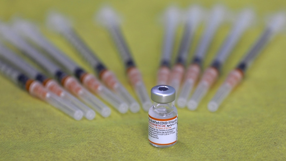 Une fiole de vaccin Pfizer et plusieurs seringues.
