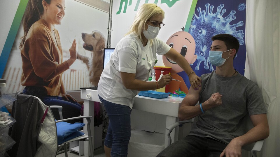 Un jeune homme en santé se fait vacciner par une infirmière.