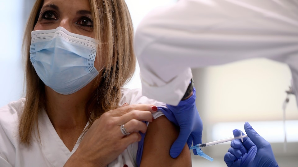 La femme reçoit le vaccin sur le bras.