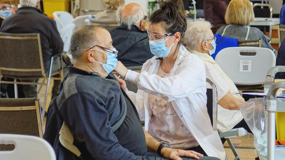 Un citoyen reçoit une première dose de vaccin contre la COVID-19 au centre de vaccination de Mont-Joli.