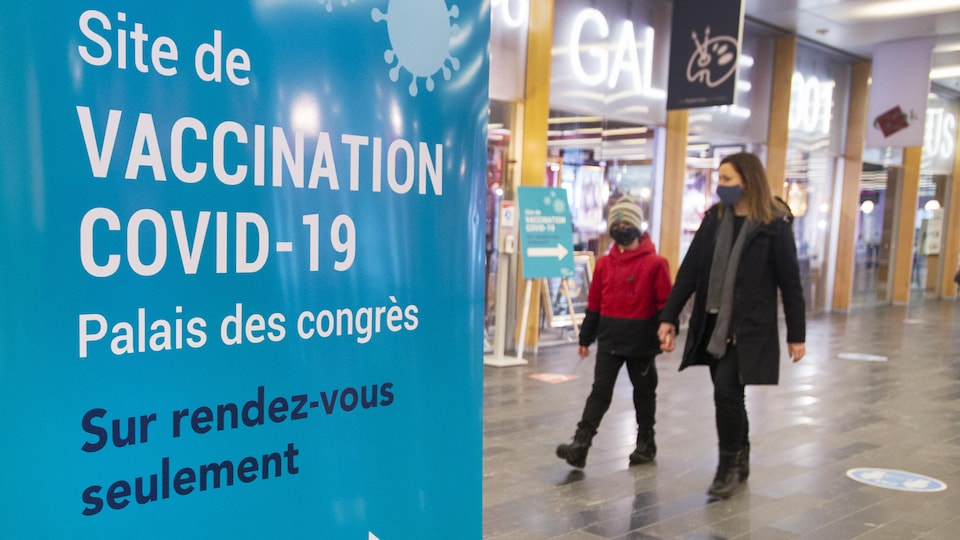 Des gens marchent près d'une clinique de vaccination à Montréal.
