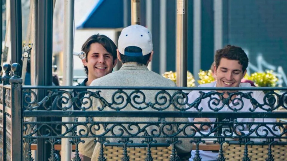 Trois personnes souriant sans masque à la terrasse d'un bar