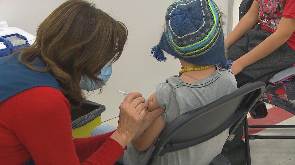 Une infirmière administre un vaccin à un enfant.