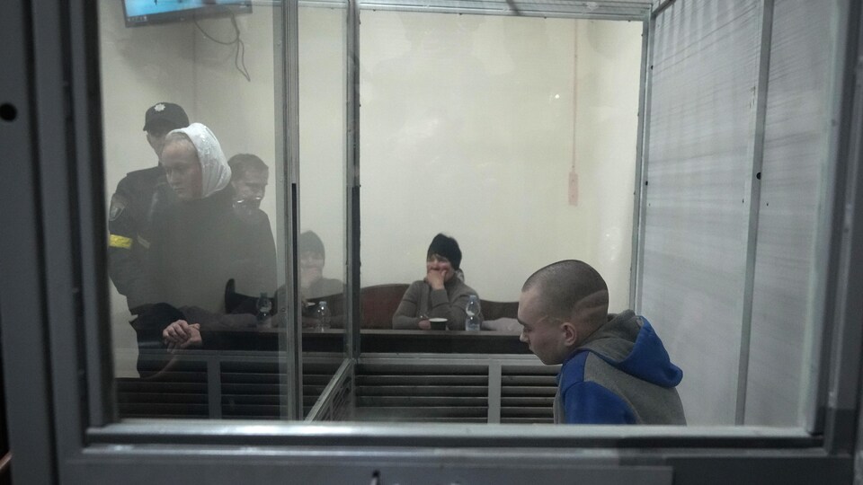 Vadim Chichimarine in the defendant's box with a woman looking disappointed behind him.