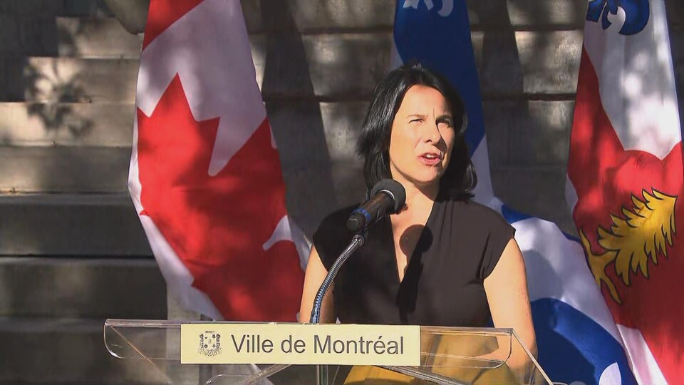 Valérie Plante parle derrière un lutrin, lors d'une journée ensoleillée.