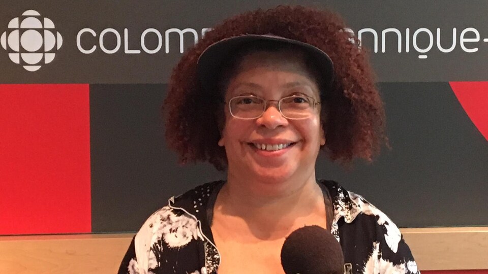 Une dame assise dans un studio de radio.