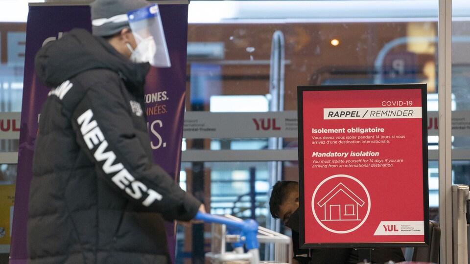 Une pancarte rappelle aux voyageurs de faire leur quarantaine à l'aéroport Montréal-Trudeau, le 29 décembre 2020.