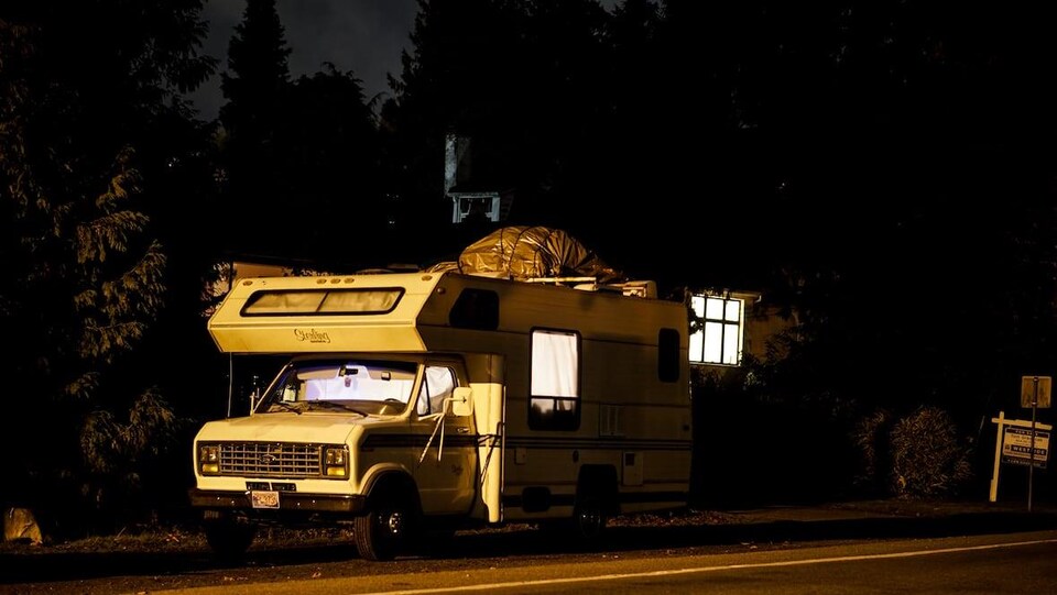Un véhicule récréatif stationné en pleine nuit dans un rue résidentielle du Grand Vancouver. 
