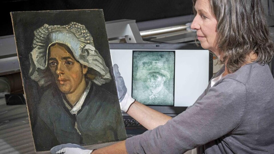 Une femme portant des gants manipule une toile et une image de rayons X de Van Gogh figure à l'arrière-plan. 