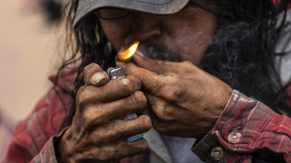 Un homme fume de la drogue dans le quartier Downtown Eastside de Vancouver.