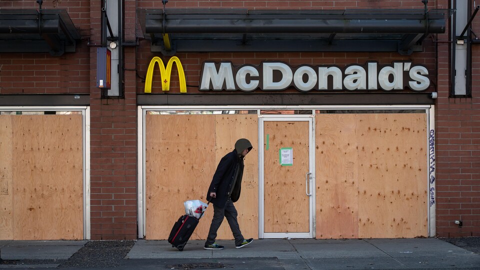 Un piéton marche devant un restaurant de la chaîne McDonald's fermé en raison de la pandémie.