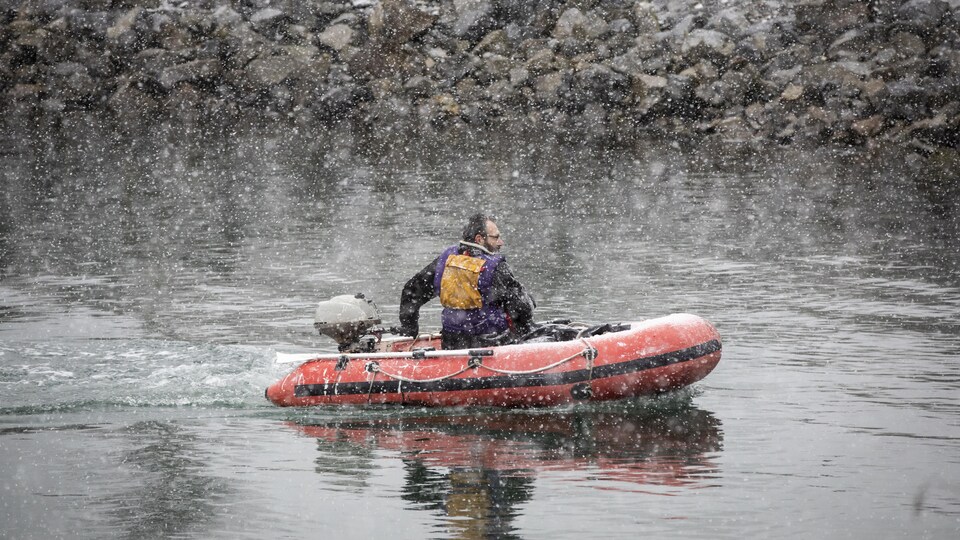 Un homme navigue dans False Creek lors d'une tempête de neige le 29 novembre 2022. 