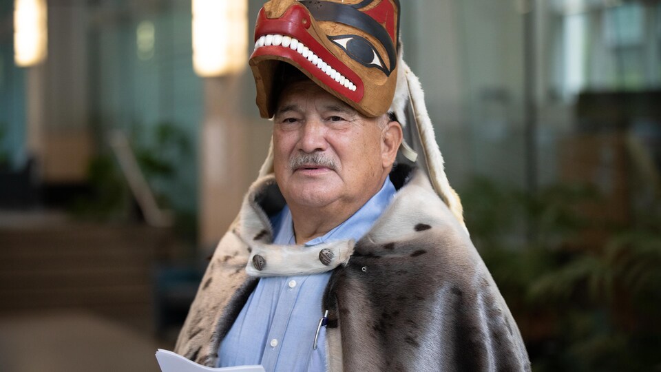 Plan serré du chef Roy Jones, arborant un habit traditionnel autochtone. 