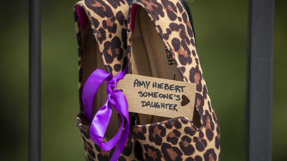 Une note accrochée à une paire de souliers féminins indique : « Amy Hierbert, la fille de quelqu'un ».