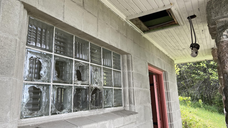 Des carreaux de vitres cassés sur un bâtiment en brique.