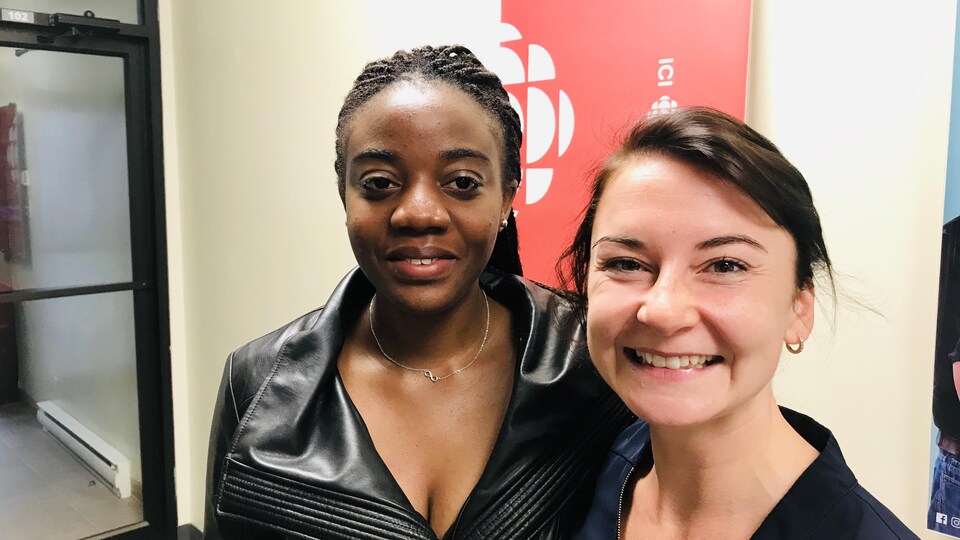Deux femmes devant l'affiche de Radio-Canada.