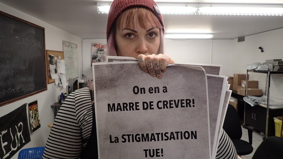 Vanessa Lefebvre Constantineau, rédactrice au journal « L'Injecteur », tient dans ses mains l'une des affiches de la campagne de sensibilisation qui se déroule en ce moment à Montréal. Sur l'affiche on peut lire: « On en a marre de crever! La STIGMATISATION TUE! »