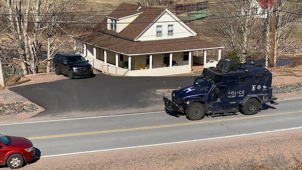 A magnificent armored vehicle in front of a country house, on a rural road.