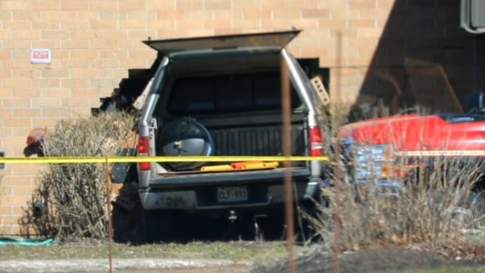 Une camionnette entrée dans un mur de briques.