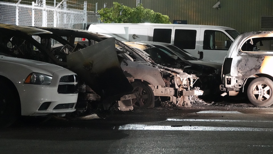 Des vehicules accidentés et incendiés immobilisés dans un stationnement.