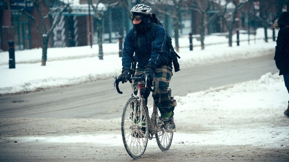 Un cycliste brave les éléments durant la saison froide.