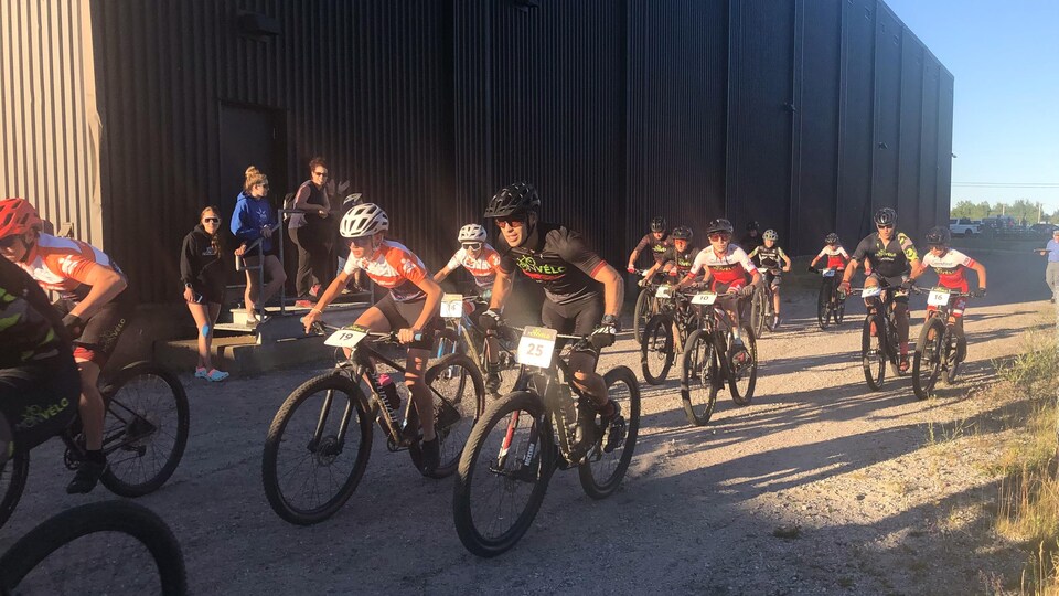 Une douzaine de cyclistes prennent le départ d'une course.