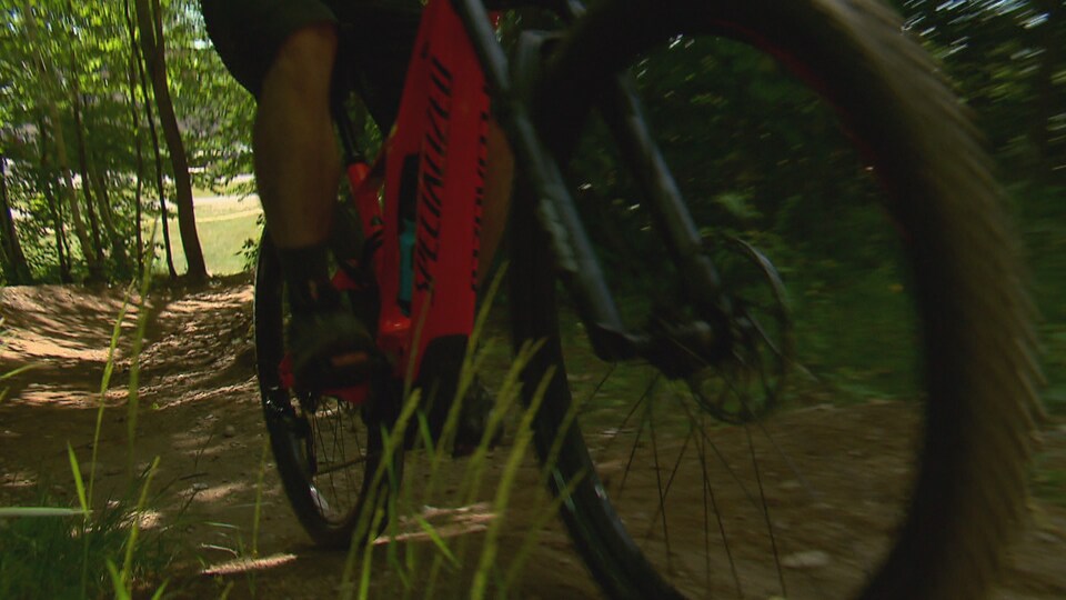 Un cycliste qui utilise un vélo de montagne électrique au Mont-Sainte-Anne.