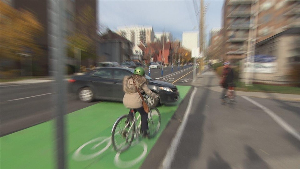 La cycliste rencontre un véhicule qui effectue un virage dans sa direction.