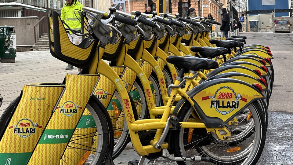 Des vélos jaunes stationnés dans une rue d'Helsinki.